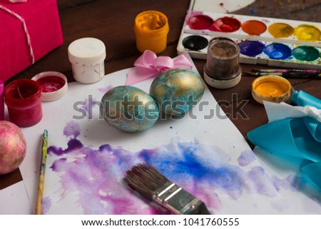 Preprimary painting of Easter Eggs, Brushes, Paints, Eggs on the Dark Wooden Table. Easter concept.