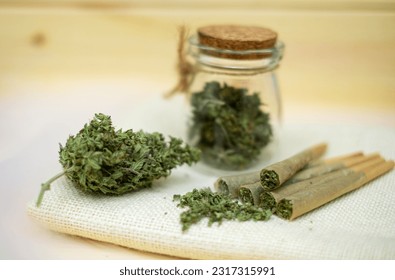 Pre-Roll marijuana joint with cannabis buds in a clear glass jar 