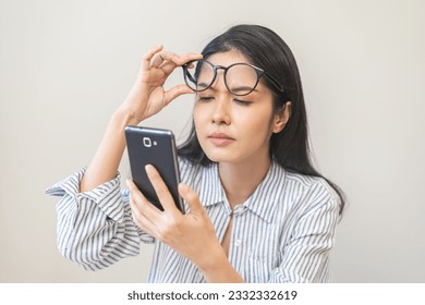 Presbyopia, Hyperopia middle aged asian woman holding eyeglasses problem with vision blurred ,trying to read text message from smart mobile phone screen, eye disease of old, eyesight farsightedness.