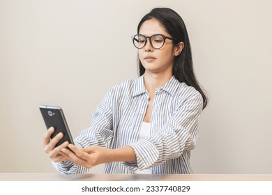 Presbyopia, Hyperopia middle aged asian woman holding eyeglasses problem with vision blurred ,trying to read text message from smart mobile phone screen, eye disease of old, eyesight farsightedness.