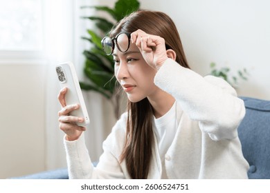 Presbyopia, Hyperopia middle aged asian woman holding eyeglasses problem with vision blurred ,trying to read text message from smart mobile phone screen, eye disease of old, eyesight farsightedness.
