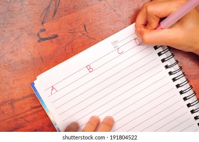 Preschool Age Child Writing Alphabet, Close Up Of Hands And Paper
