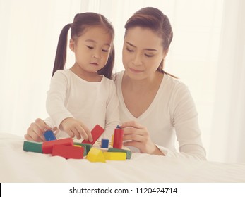 preschool age little Asia children play with colorful plastic toy blocks.Child playing with building blocks learning new skills.