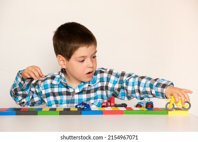 Preschool Boy 4 Years Old Plays With Cars And Toys, Games For Children, Toy Store On A White Background.