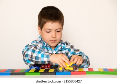 Preschool Boy 4 Years Old Plays With Cars And Toys, Games For Children, Toy Store On A White Background.