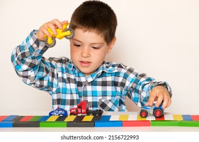 Preschool Boy 4 Years Old Plays With Cars And Toys, Games For Children, Toy Store On A White Background.