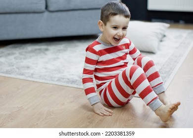 Preschool Boy In Christmas Pyjamas Sitiing On A Floor