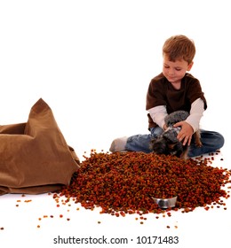 Preschool Boy Holding His Yorkie Over The Big Bag Of Dog Food He's Dumped Into The Dog's Bowl.