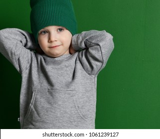 Preschool Boy Kid Standing In Gray Hoodie Sweater And Winter Hat On Green Mint Background