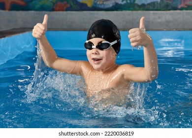 Preschool boy learning how to swim in a pool wearing swimming cap and goggles - Powered by Shutterstock