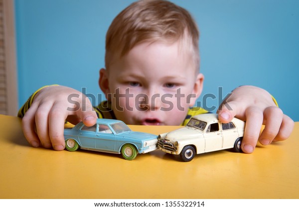 Preschool boy\
playing with toy car on a table at home or daycare. Educational\
toys for preschool and kindergarten\
child.