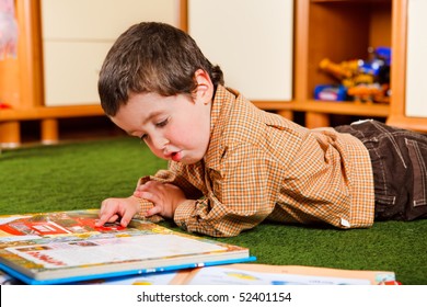 Preschool Boy Reading A Large Book