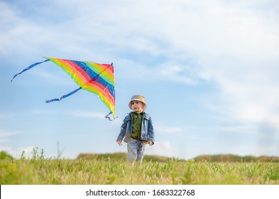 A preschool boy runs in the meadow, flying a kite in his hands that flies in the blue sky. Children's games in nature. Active childhood - Powered by Shutterstock