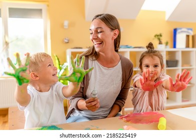 Preschool Children With A Teacher Playing With Washable Finger Paints