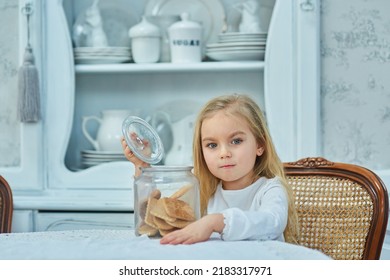 A Preschool Girl Holds A Cookie Jar In A Vintage Dining Room. Retro Interior.