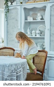 A Preschool Girl Holds A Cookie Jar In A Vintage Dining Room. Retro Interior.