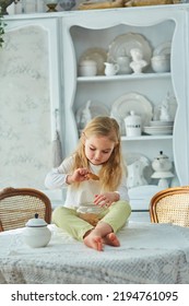 A Preschool Girl Holds A Cookie Jar In A Vintage Dining Room. Retro Interior.