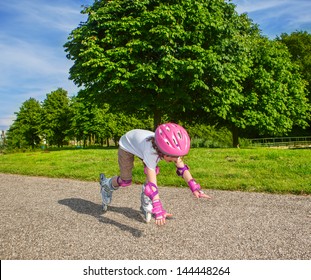 Preschool girl with inline roller skates on, falling down