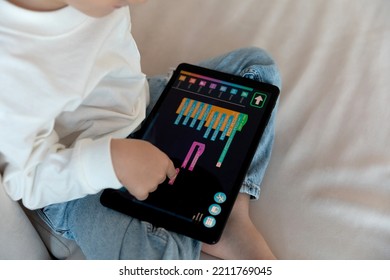 A preschool kid programmer coding at tablet pc, uses machine language