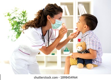Preschool pediatrician performing a throat examination in the office of a medical clinic  