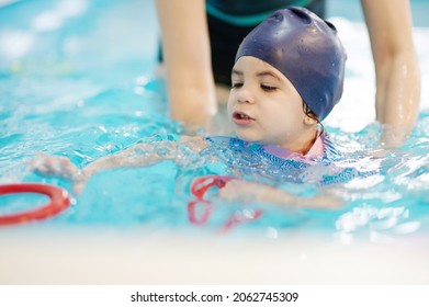 Preschool Swim Lessons For Kids Theme. Child Pick Up Ring In Swimming Pool