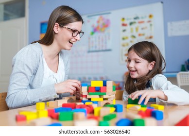 Preschool Teacher And Cute Girl Having Fun Time Playing