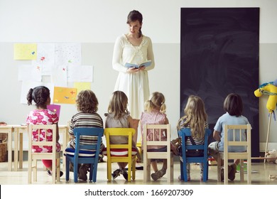 Preschool teacher reading to students Foto Stock