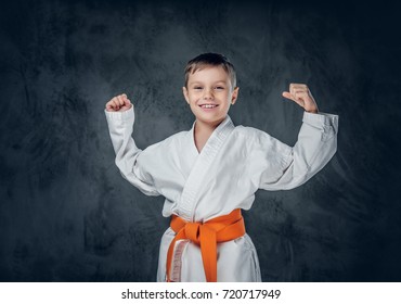 Preschooler Boy Dressed In A White Karate Kimono With Orange Belt.