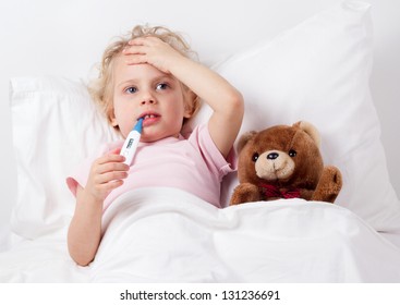 Preschooler Child Feeling Sick, Lying In Bed With Fever, Measuring Body Temperature With Thermometer. Coronavirus Symptoms. Home Quarantine During Epidemic, Seasonal Outbreak Of Respiratory Diseases