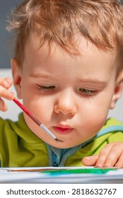 Preschooler engaged in creative learning through hands-on painting.