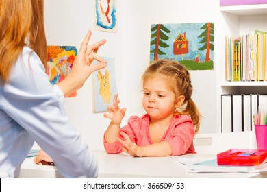 Preschooler playing hand game with teacher