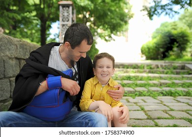 Preschooler Son And Father With Broken Arm Using An Abduction Orthosis Pillow Walk In City On Sunny Day And Smile. Positive Trusting Generations Relationships . Freedom Of Movement In Case Of Injury