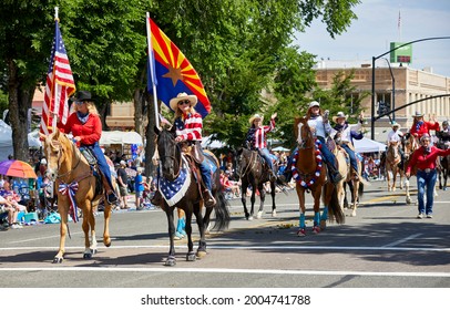 Prescott, Arizona, USA - July 3, 2021: Female participant riding a horse while holding a flag in the 4th of July parade
