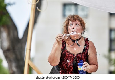 Prescott, Arizona, USA - July 3, 2021: Woman blowing bubbles while riding on a float in the 4th of July parade