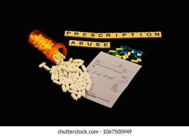 Prescription Abuse Is Spelled Out With Tiles, Spilled Prescription Pills On A Prescription Pad On A Black Background