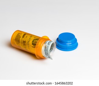 Prescription Drug, Medicine Pill Bottle With 100 Dollar Bill Inside Isolated On White Background. Concept Of Rising Drug, Health Care, Medical Insurance Cost