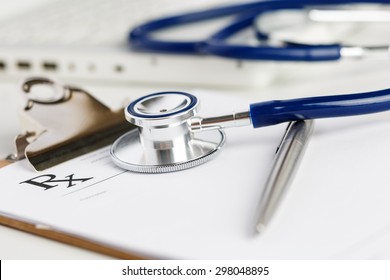 Prescription form lying on table with stethoscope and silver pen. Medicine or pharmacy concept. Empty medical form ready to be used. Medicine doctor tools and instruments at working table