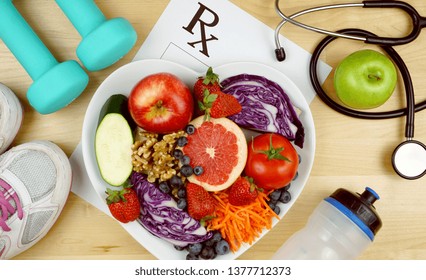 Prescription For Good Health Overhead With Stethoscope, Healthy Fresh Food And Exercise Equipment.