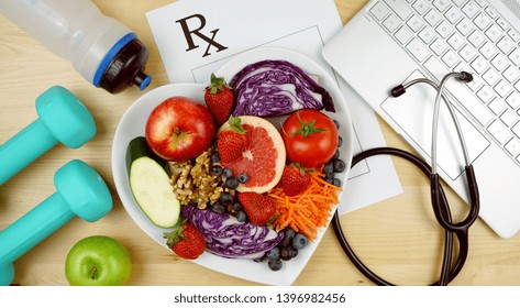 Prescription For Good Health Overhead With Stethoscope, Healthy Fresh Food And Exercise Equipment.