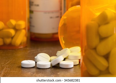 Prescription painkillers, oxycodone, spilled from a bottle onto a table with out of focus
bottles.