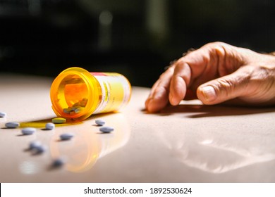 Prescription Pill Bottle Dropped With Tablets Scattered With A Man's Hand. Depicting Drug Addition.