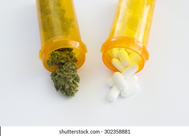 Prescription pill bottles with marijuana buds and white prescription pills