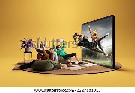 Presence effect. Astonished thrilled youth, girls and boys sitting in front of huge 3D model of TV screen at home interior and watching online broadcast of american football match. Winner emotions