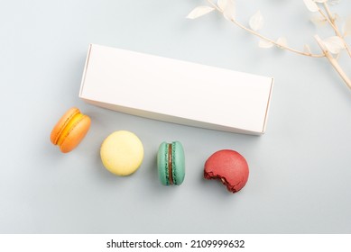 Present Box Mockup And Colorful Macarons On A Blue Background With Dry Branch