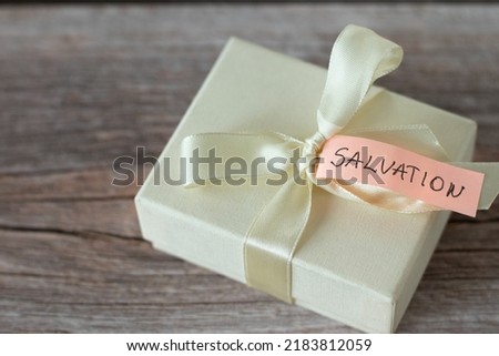 Present box with a ribbon and a text note with handwritten word 