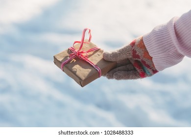 Present in hand on background of winter park