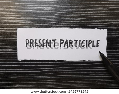 Present participle writting on table background.