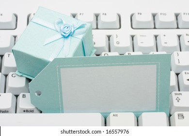 Present sitting on computer keyboard with blank gift tag, gift chopping online