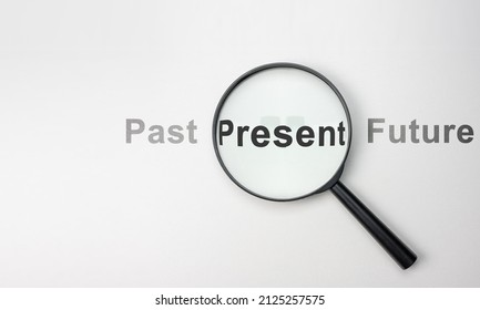 Present wording inside of Magnifier glass on white background for focus current situation, positive thinking mindset concept. present in focus. wide, top view - Shutterstock ID 2125257575