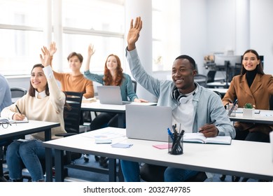Presentation, Convention Concept. Portrait of smiling international people participating in seminar at modern office, raising hands up to ask question or to volunteer, diverse group sitting at tables - Shutterstock ID 2032749785